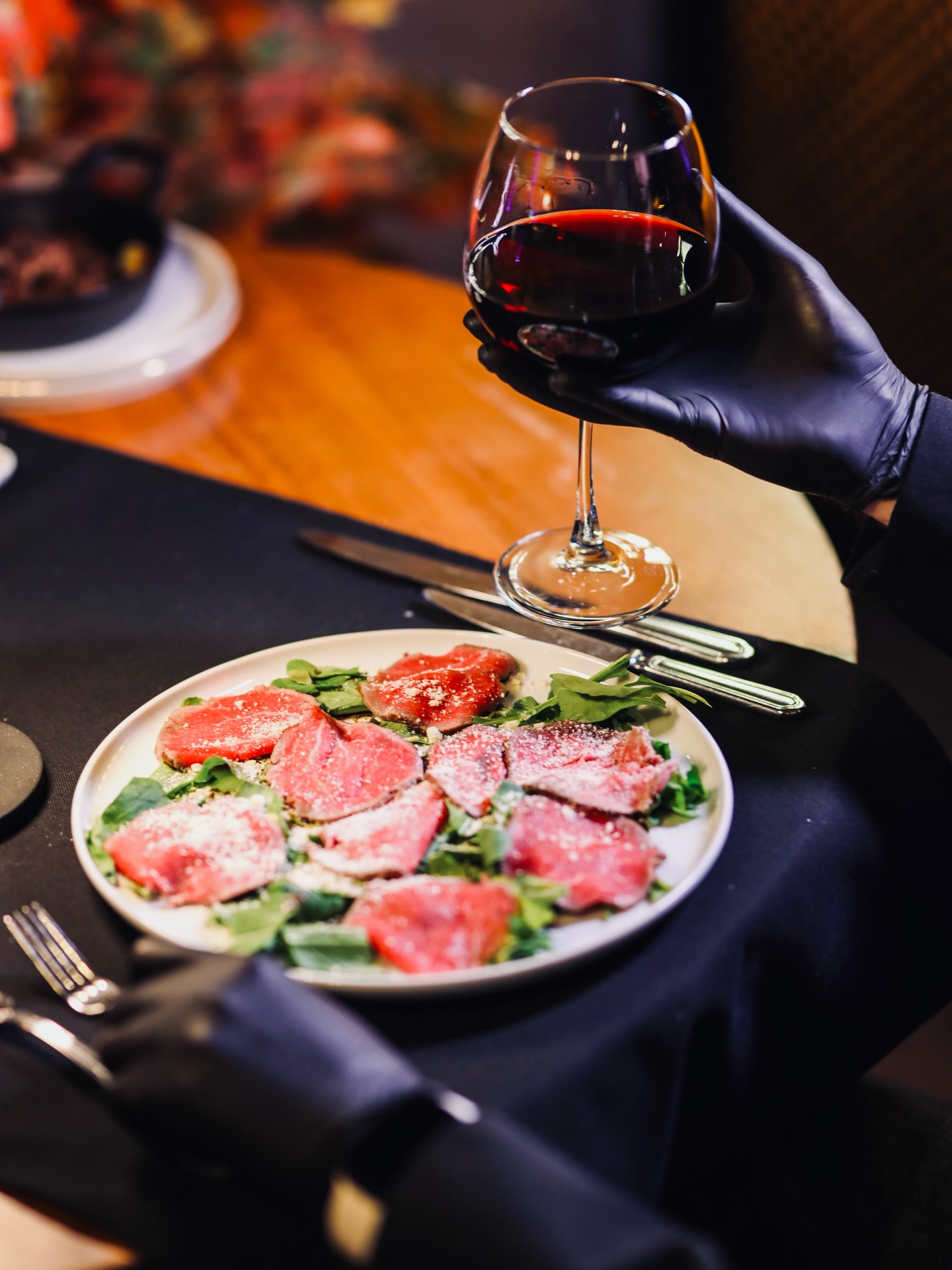 Dana carpaccio — roka, parmesan ve kadeh şarap servisi
